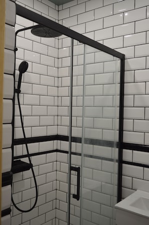 A glass-enclosed shower with a handheld showerhead and a wall-mounted faucet. - Town House in the centre of Alte. Family or group retreat to secret of Algarve (Alte)