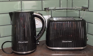 Zwei schwarze Russell Hobbs Geräte, ein Wasserkocher und ein Toaster, stehen auf einer Küchenarbeitsplatte.