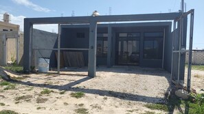 Een bouwplaats met een metalen frameconstructie, een kiezelgrond en bouwmaterialen.