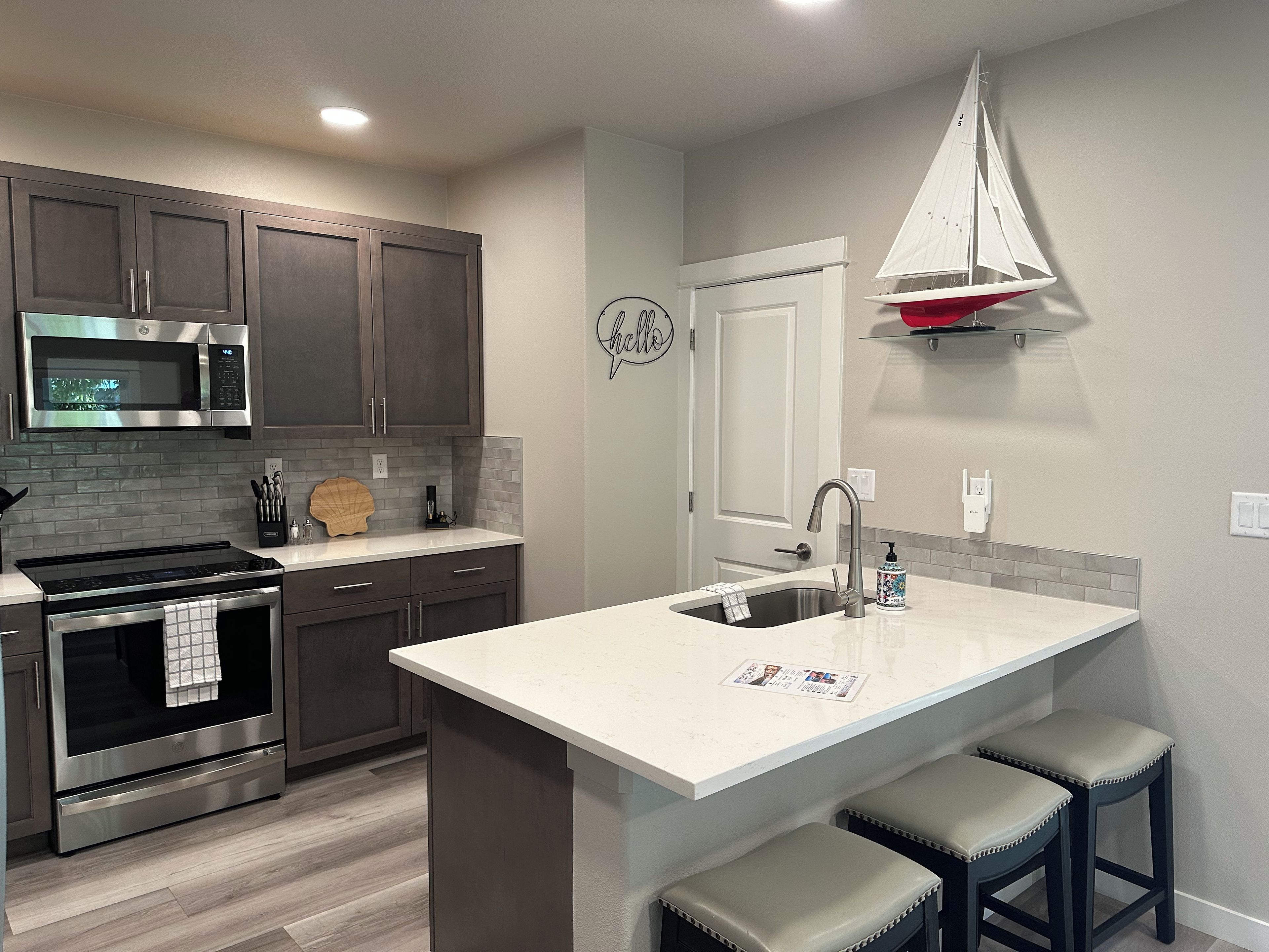 A modern kitchen with a built-in microwave, oven, and stainless steel range hood.