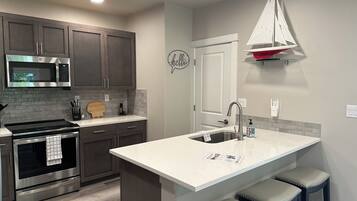 A modern kitchen with a built-in microwave, oven, and stainless steel range hood.