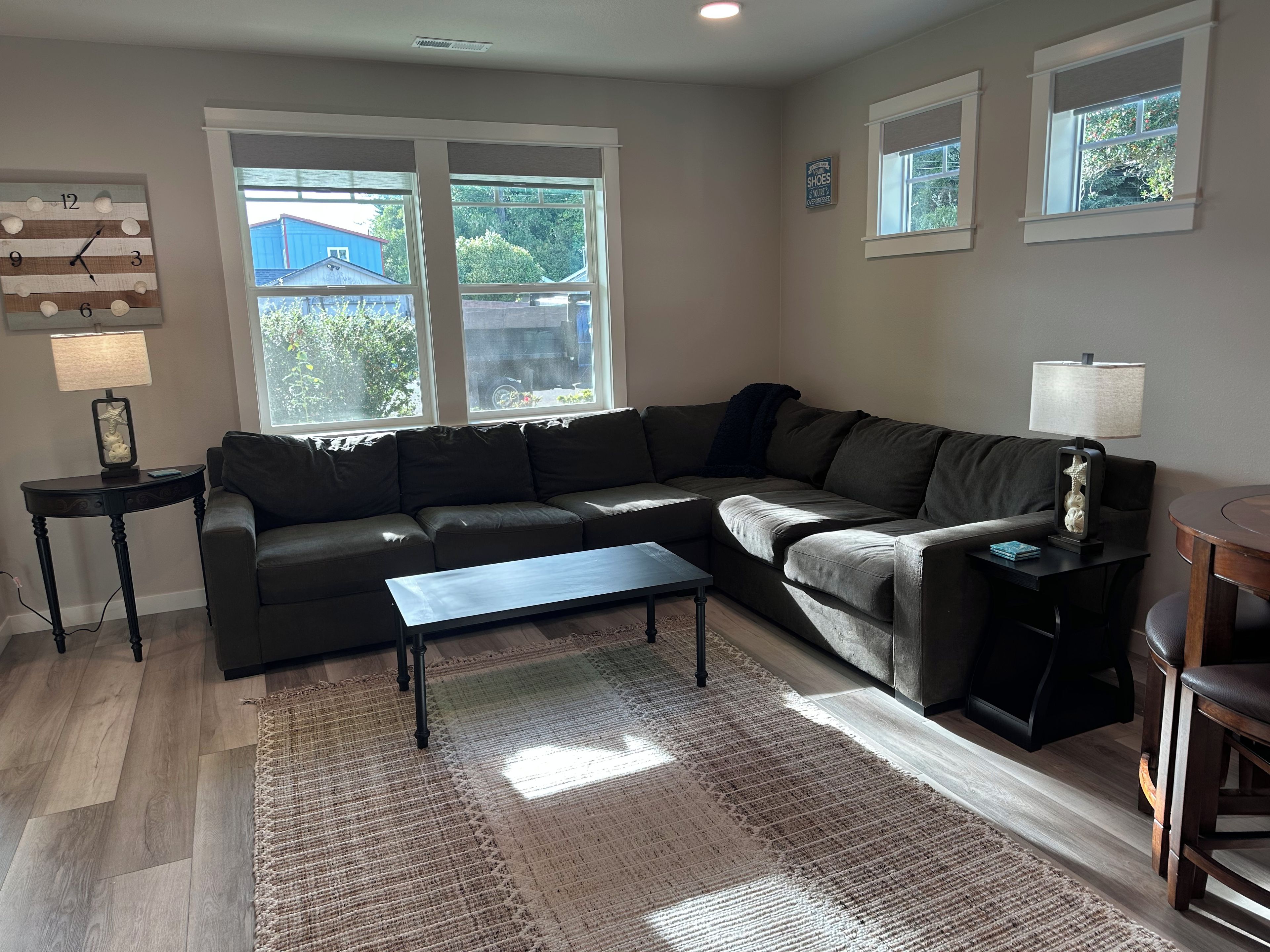 A living room with a sectional sofa, a coffee table, a rug, and a side table with a lamp.