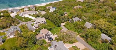 Oversigtsbillede af et kystnært boligområde med huse, veje og en strand.