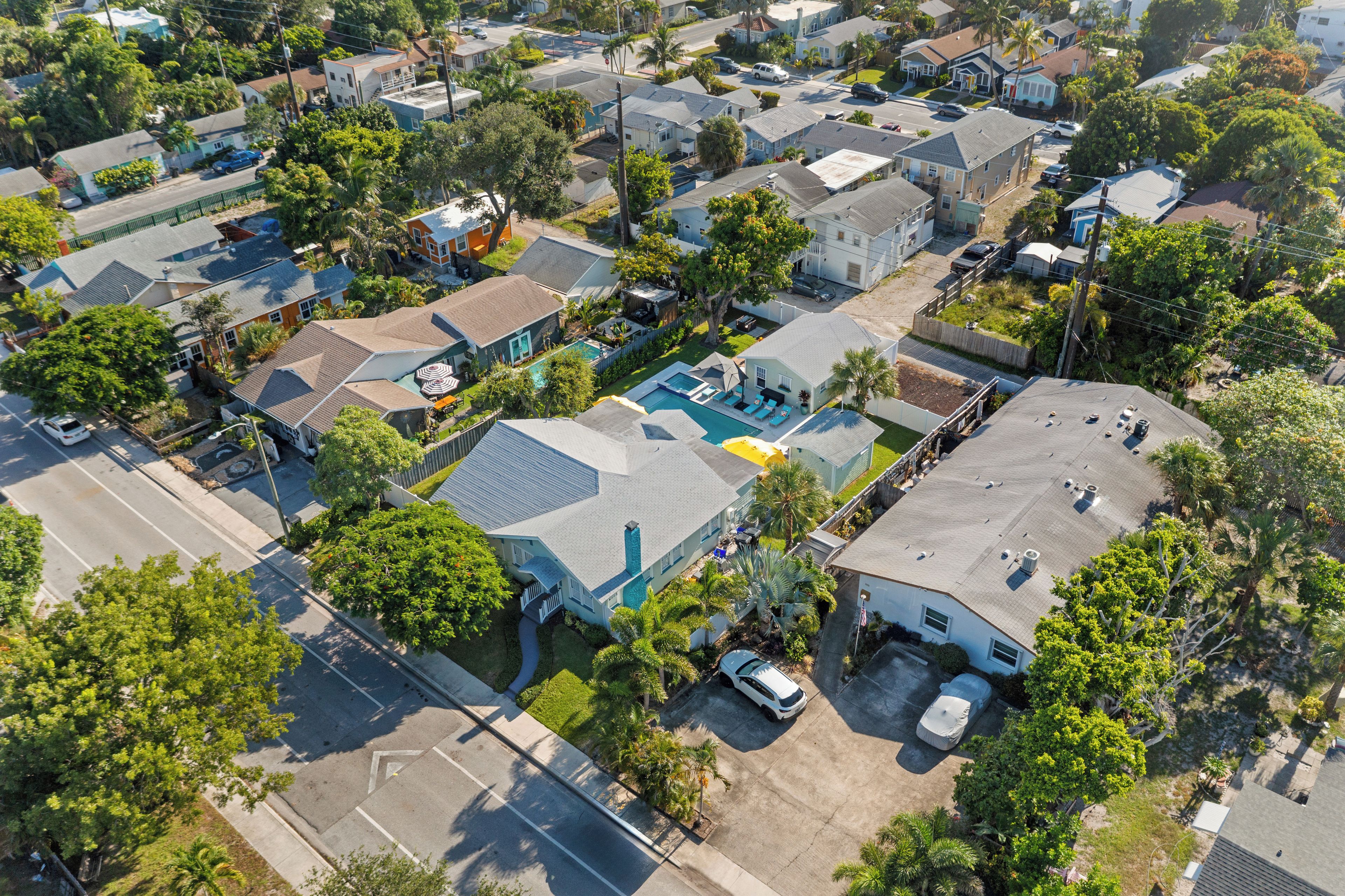 An aerial view of a residential area with houses, a swimming pool, and a street.