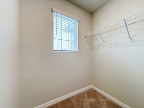 A room with a window, a clothes drying rack, and a carpeted floor. - Windsor Island | 10BR Luxury Haven + Game Room (Davenport)