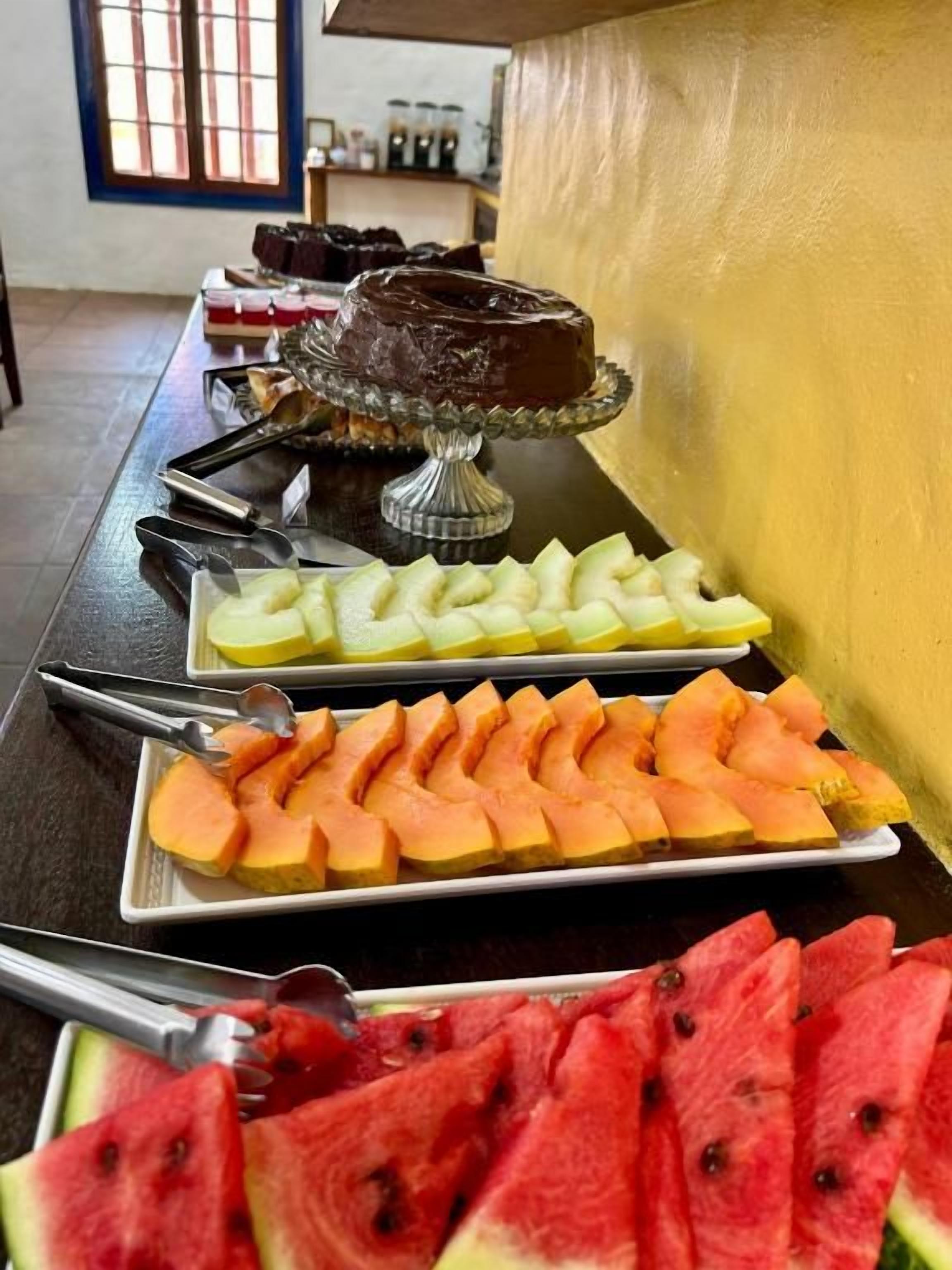 Ett bord med ett urval av olika frukter och en chokladtårta.
