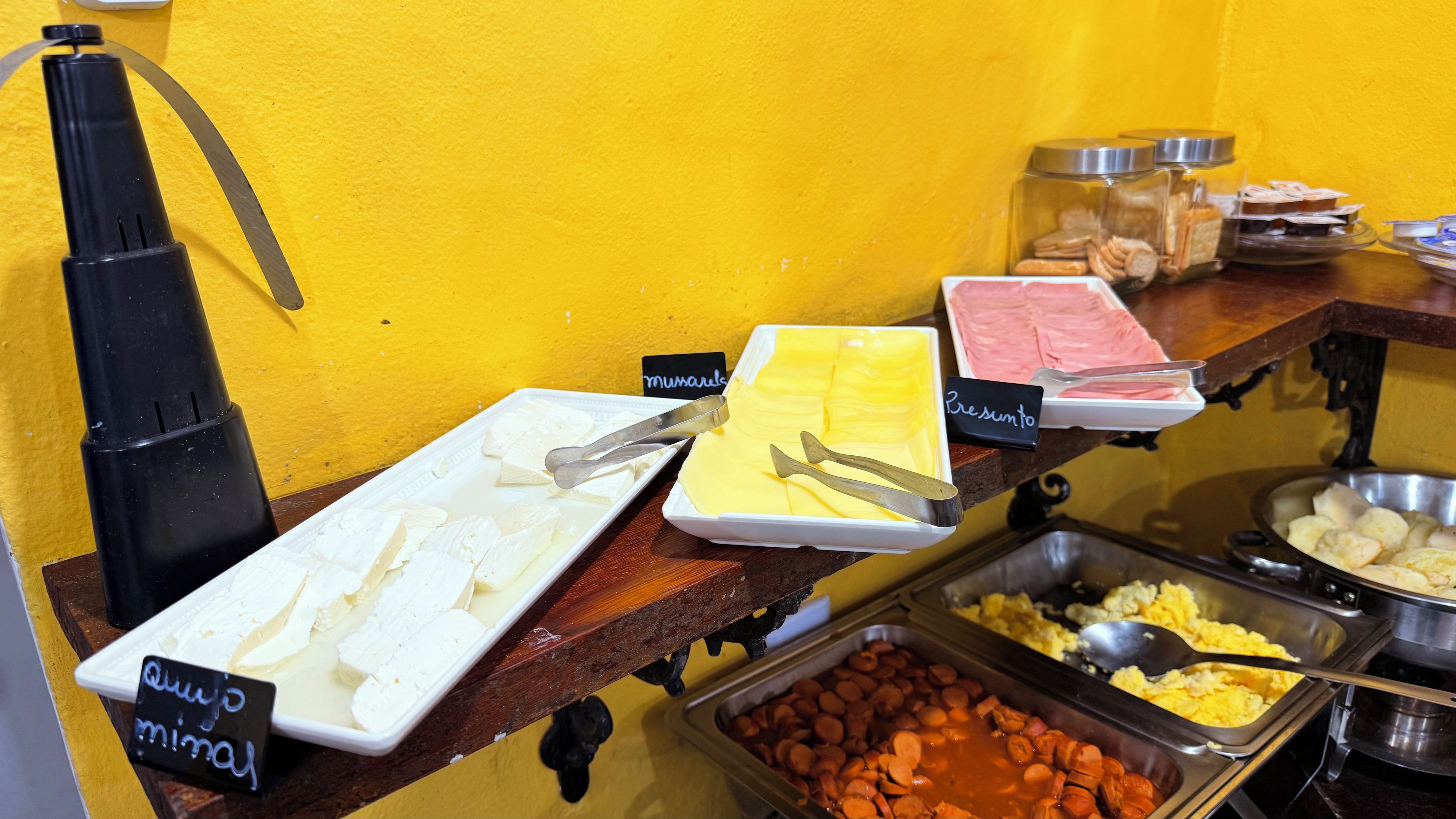 A buffet with various food options including cheese, pastries, and meats.
