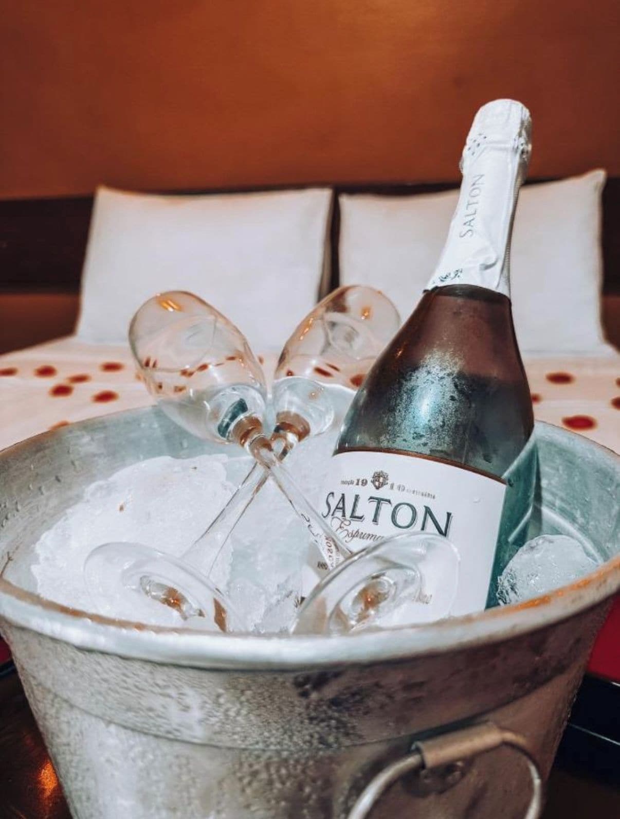 Eine Flasche Salton-Champagner in einem Metallkübel mit Eis und Gläsern.