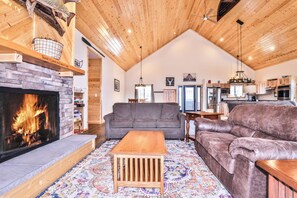 A cozy living room with a fireplace, a sofa, a loveseat, and a coffee table. - Chain Of Lakes direct trail access / Free Firewood (Eagle River)