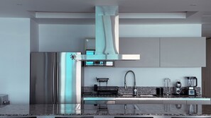 A modern kitchen with a stainless steel refrigerator, a built-in oven, a coffee machine, and a sink. - Península Sky Residence | Ixtapa Beachfront (Ixtapa Zihuatanejo)