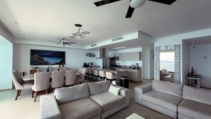 A modern living room with a sofa, dining area, and kitchen. - Península Sky Residence | Ixtapa Beachfront (Ixtapa Zihuatanejo)