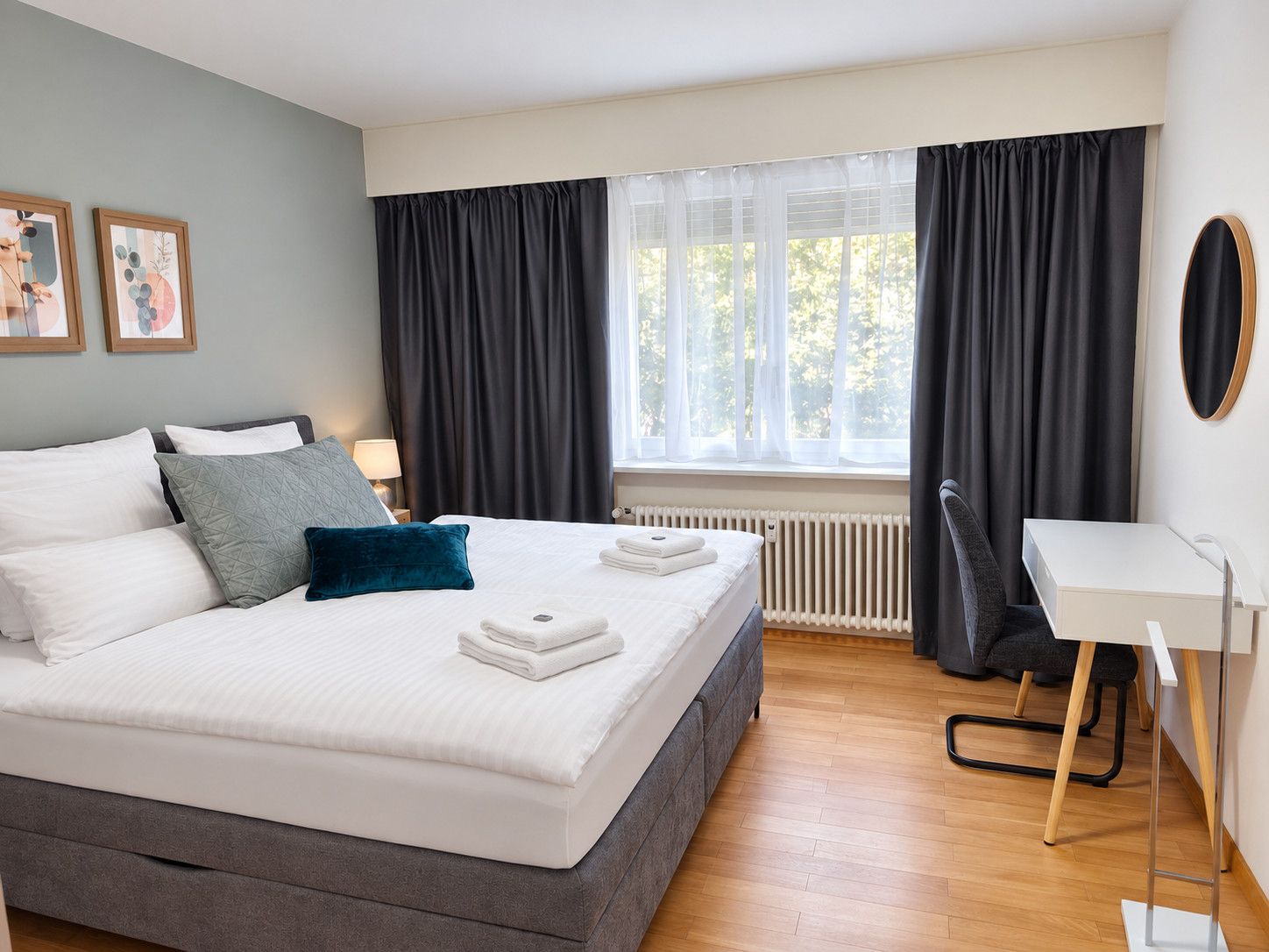 Une chambre d’hôtel moderne, dotée d’un grand lit, d’un bureau et offrant une vue sur l’extérieur.