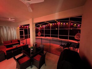 A room with a seating area, a table, and a view of the outside. - 5BR Pool Home Near Disney (Kissimmee)
