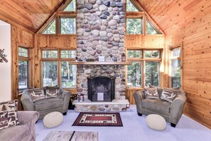 A log cabin interior with a stone fireplace, two sofas, and large windows. - Nestled on the banks of East Bay Little Saint Germain Lake! (St Germain)
