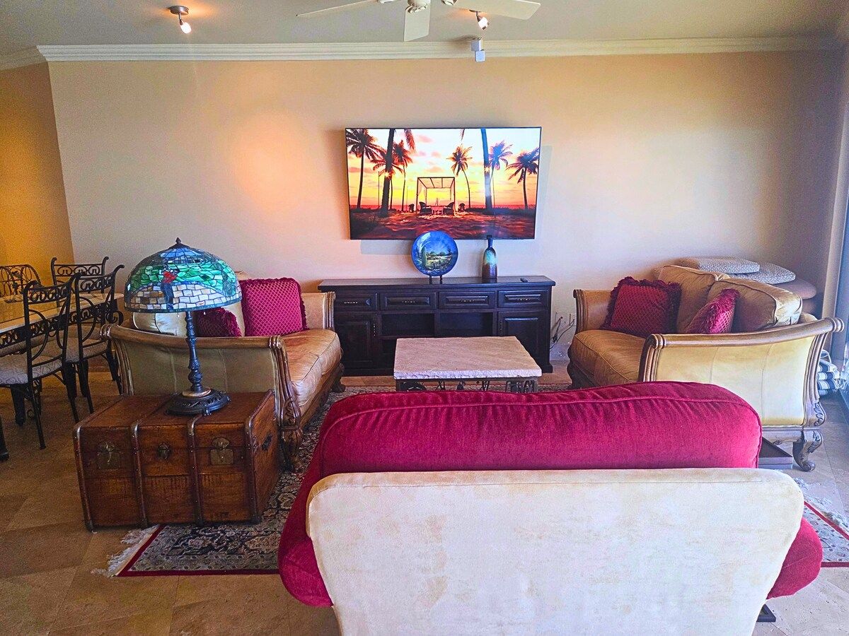 A living room with a sofa, armchairs, a coffee table, a television, and a globe.