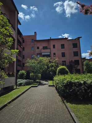 A multi-story building with a paved walkway leading to a gated entrance. - Cozy apartment located right near the Rescaldina train station (Rescaldina)