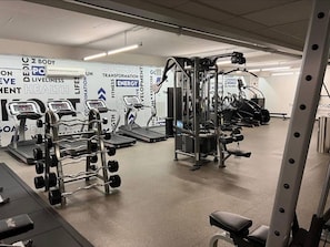 A gym with treadmills, weight machines, and a wall with motivational phrases. - Hollywood Central with Pool|Free Parking|Gym (Los Angeles)