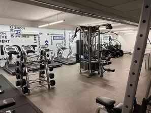 A gym with various exercise equipment, including treadmills, weight machines, and a squat rack. - Hollywood Central with Pool| Free Parking|Gym (West Hollywood)