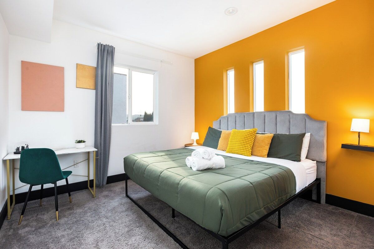 Een hotelkamer met een bed, een bureau, een stoel en een raam.