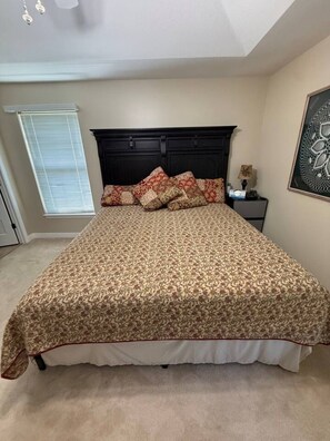A bedroom with a large bed, a dark headboard, a window with blinds, and a framed artwork on the wall. - Hop Skip & Jump-Good Night Sleep (Boonville)