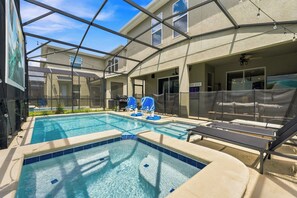 Ein Poolbereich mit Whirlpool, Liegestühlen und einer überdachten Terrasse.