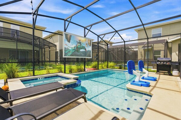 En swimmingpool med ett bubbelbad, solstolar och en grill.