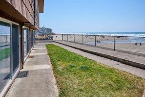 A coastal walkway with a grassy area and a view of the beach. - Oceanfront Condo With Kitchen, Pool, Hot Tub (Lincoln City)