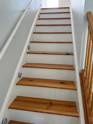 A staircase with wooden steps and a white wall.