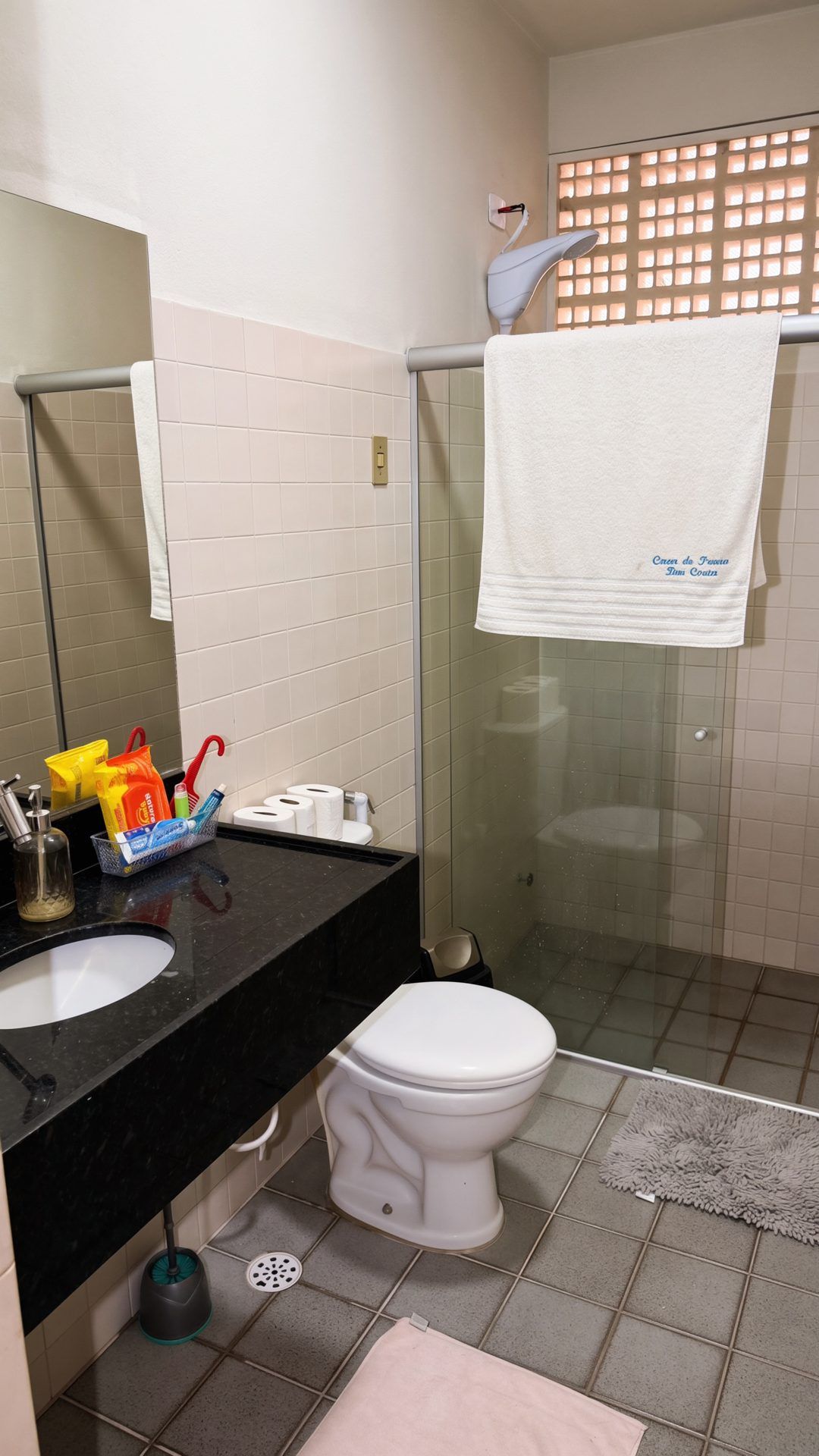 Een badkamer met een zwart wastafel, een wit toilet en een douchecabine van glas.