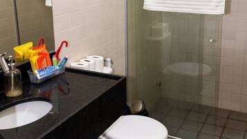 Een badkamer met een zwart wastafel, een wit toilet en een douchecabine van glas.