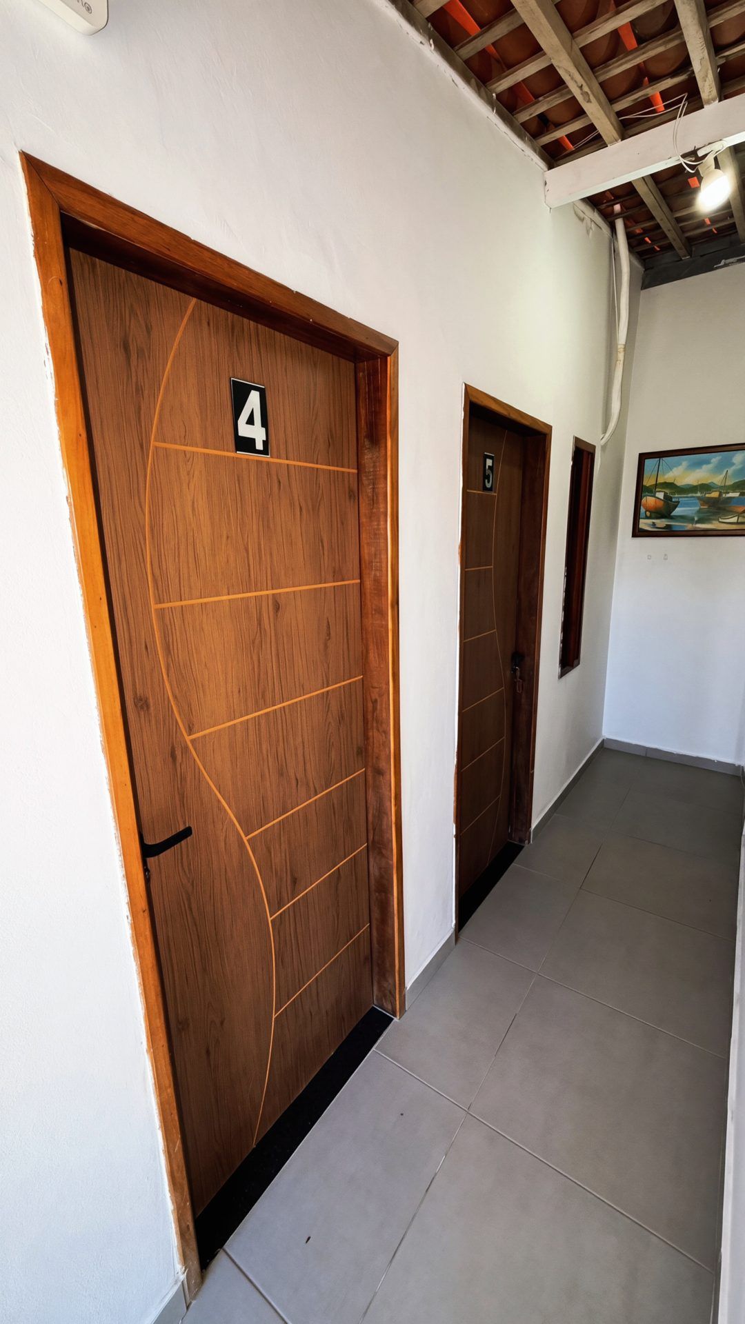 A hallway with two wooden doors, numbered 4 and 5, leading to rooms.
