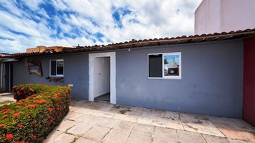 Un edificio con techo de tejas, una puerta y un pequeño ventanal.