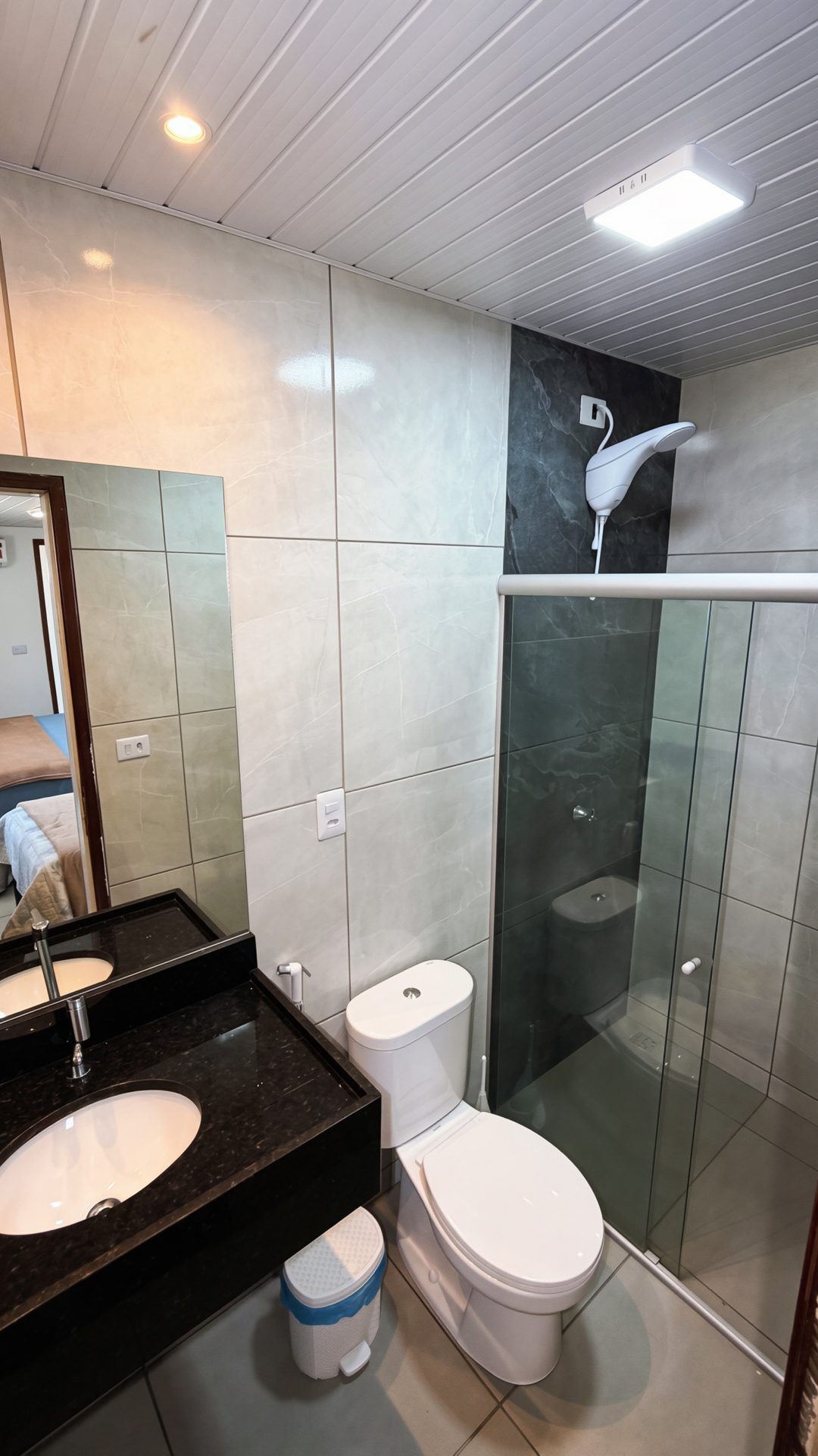 Un baño moderno con tocador, inodoro y zona de ducha.