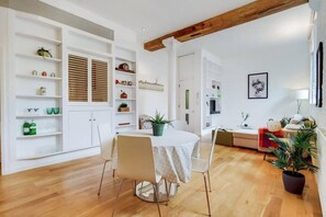 A dining area with a round table, chairs, and a wooden floor. - VY6 - Stylish 1-Bed Flat Near Borough (London)
