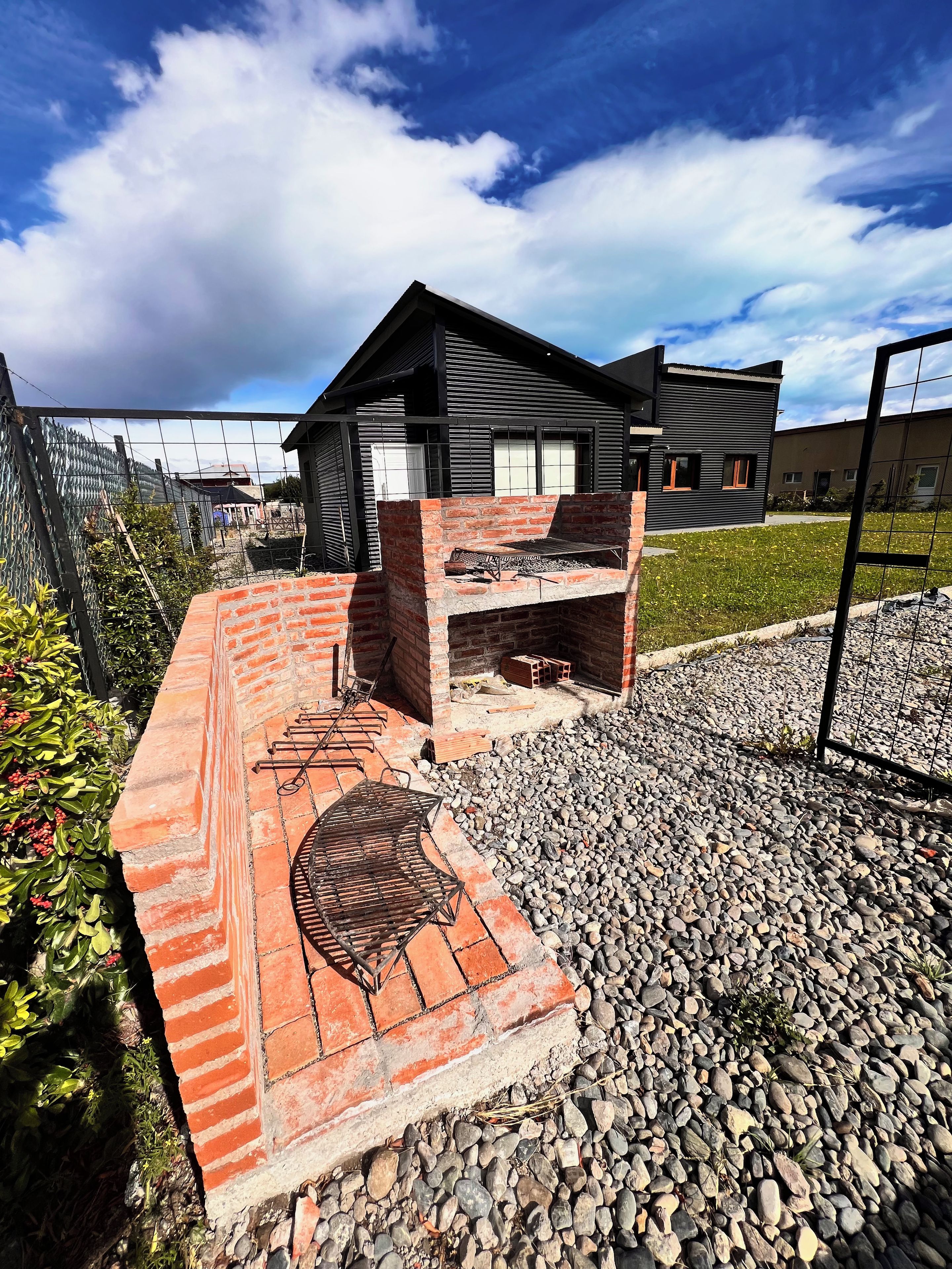 A modern outdoor barbecue area with a brick structure and a metal grill.
