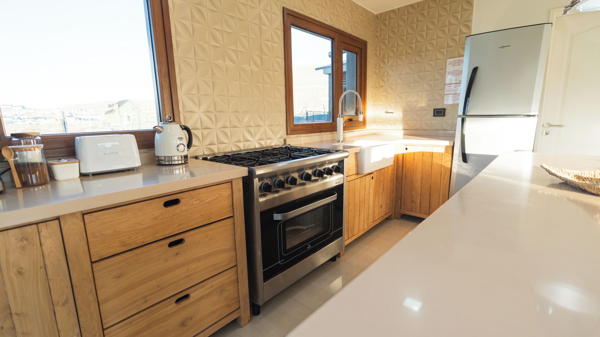 A modern kitchen with a built-in oven, a stovetop, and wooden cabinetry.