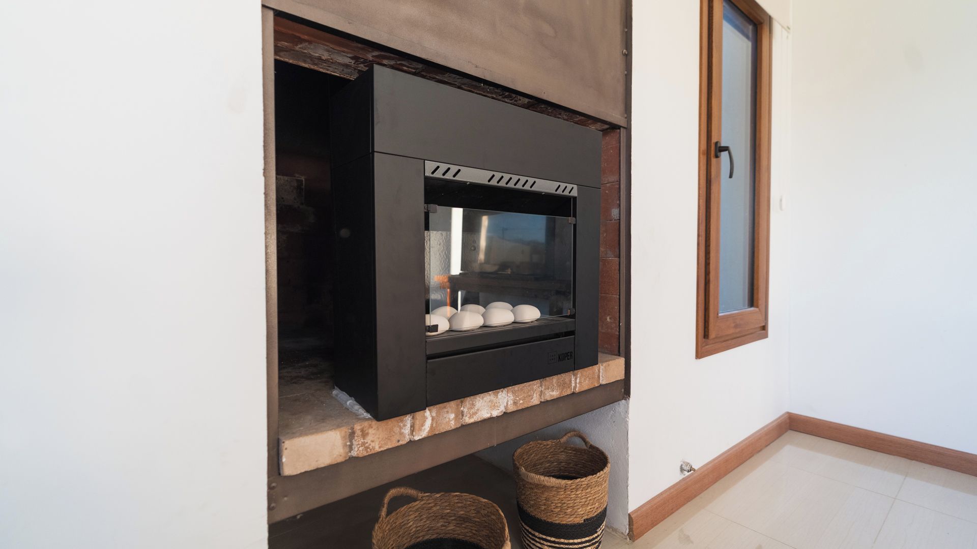 A modern kitchen with a built-in oven and a window above it.