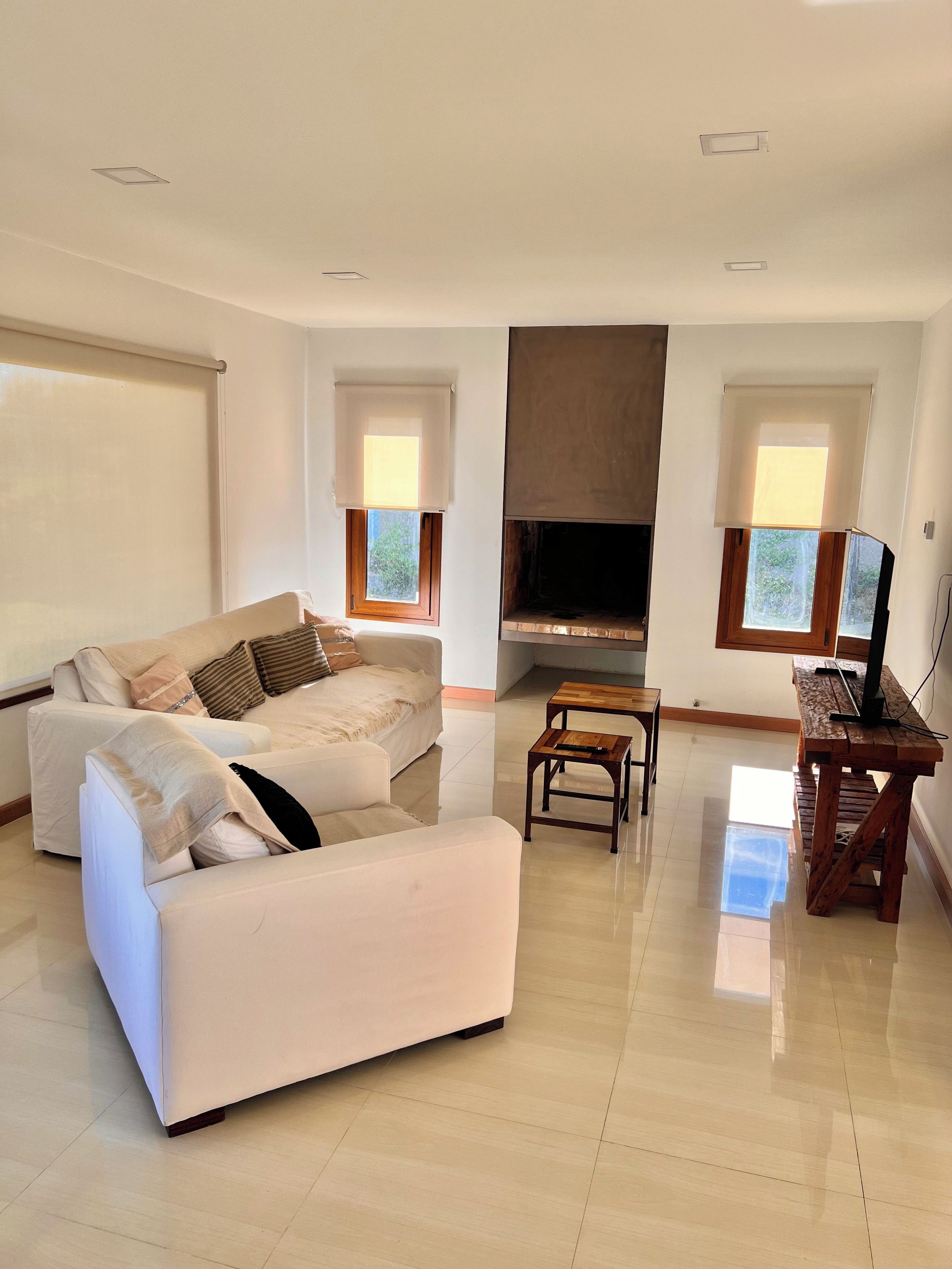 Een moderne woonkamer met een bank, een tv-meubel en een open haard.