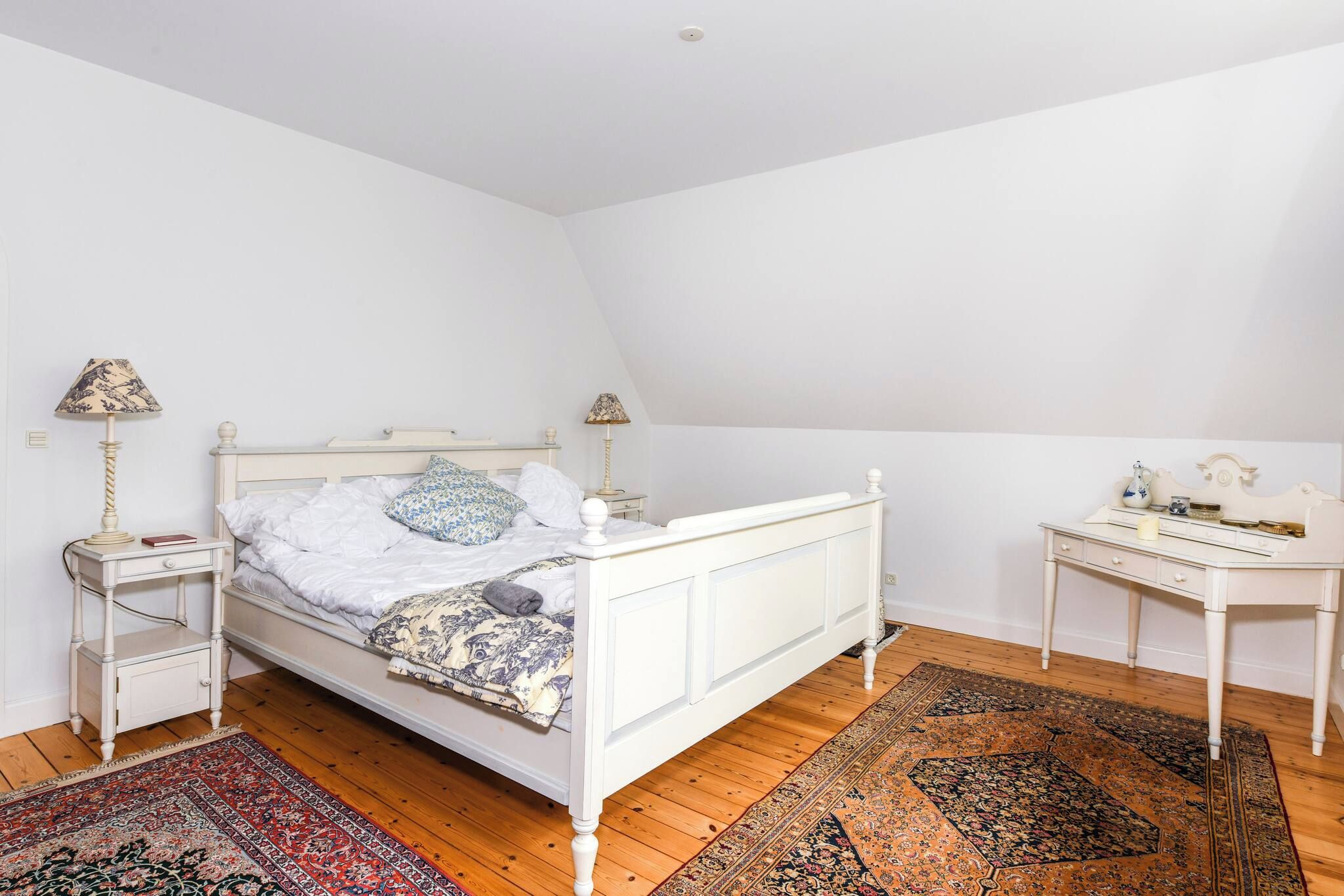 Una camera da letto con un letto singolo, due comodini, una scrivania e una sedia.