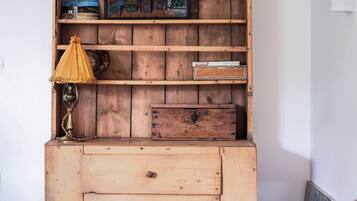 A wooden cabinet with multiple shelves, a lamp, and a framed picture.