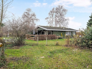 A single-story house with a sloped roof, a front porch, and a fenced yard. - 4 Star Holiday Home in Idestrup (Idestrup)