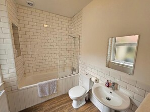 A bathroom with a white tiled shower, a toilet, and a sink. - Kings Central 3 Bedroom - Free Parking & wifi (Southport)