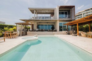 A modern two-story house with a swimming pool, outdoor seating, and a covered patio area. - Luxury 3-Bedroom Villa with Private Pool & Jacuzzi (Barú)