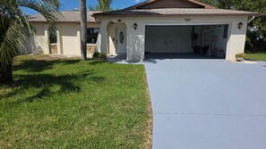 A residential garage with a number 7507, a driveway, and a lawn with a palm tree. - Waterfront Canal home with direct access to the Gulf.  2 Boat Slips and Dock. (Hudson)