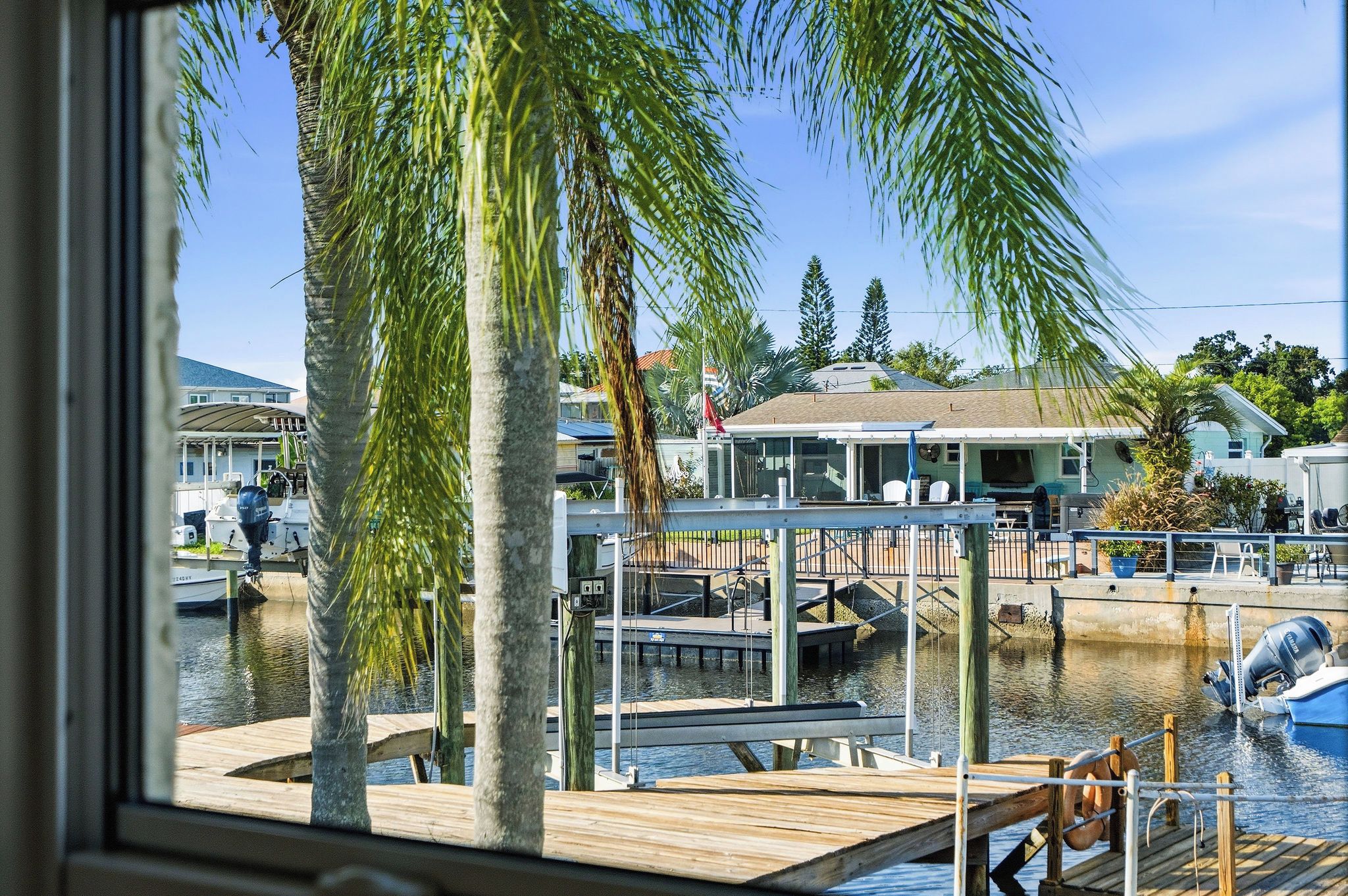 A marina with docked boats, a wooden pier, and a building with a covered area.