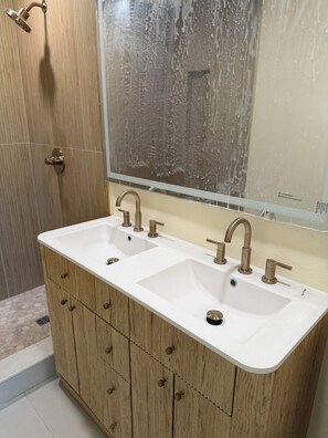 A bathroom with a wooden vanity, two sinks, and a large mirror. - Waterfront Canal home with direct access to the Gulf.  2 Boat Slips and Dock. (Hudson)