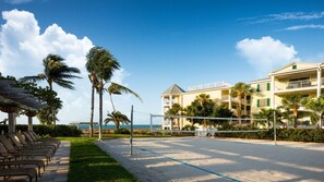 Ein Strandhotel mit Pool, Palmen und Meerblick.