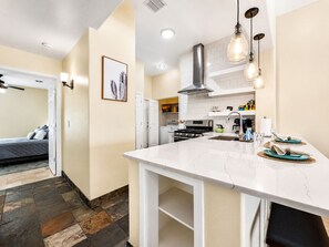 A modern kitchen with a central island, white cabinetry, and pendant lighting. - Amazing Views for Miles! Oro Valley Stunner (Oro Valley)