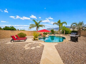A backyard with a swimming pool, red lounge chairs, a barbecue grill, and palm trees. - Amazing Views for Miles! Oro Valley Stunner (Oro Valley)