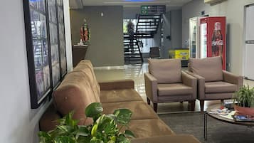 A modern lobby with a sofa, chairs, a coffee table, and a plant.